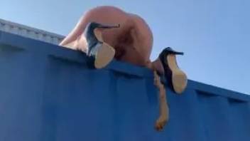 Naked blonde shit from the roof of a cargo container